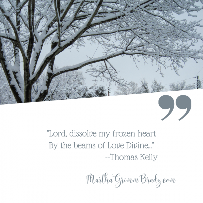 Black and white photo of a tree covered with snow.