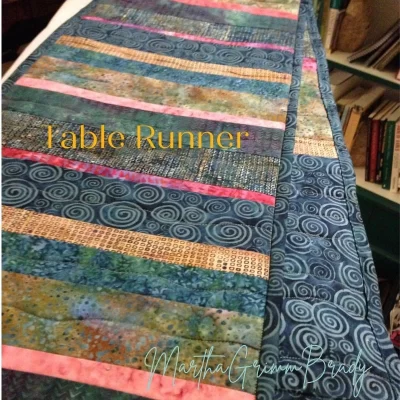 Photo of table runner made of strips in fall colors.