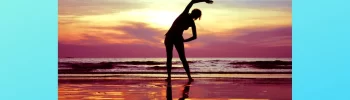 Photo of woman on the beach exercising with sunset in the background. Beautiful sunset colors.